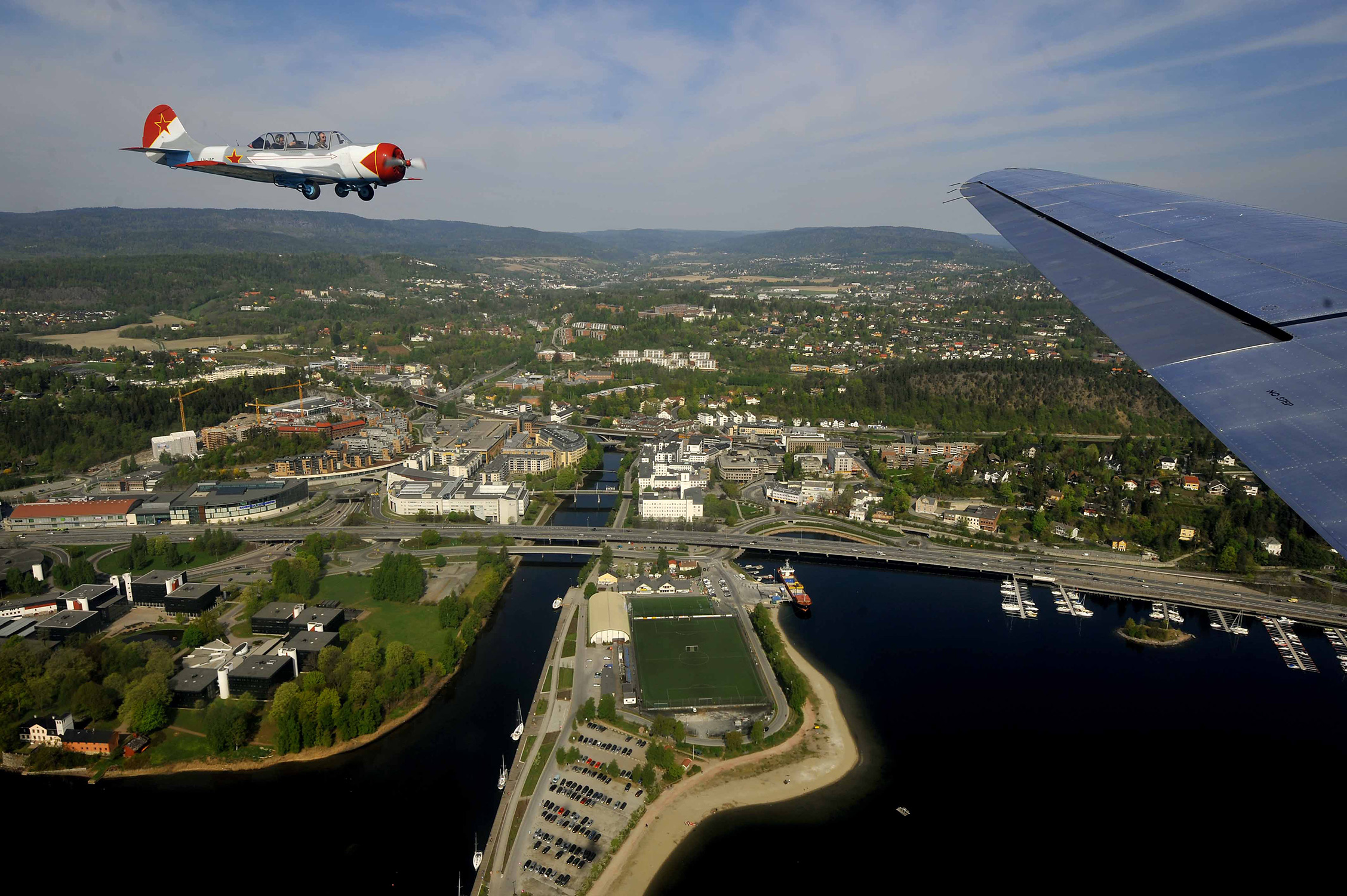 Flyfoto over Sandvika med fly i bakgrunnen